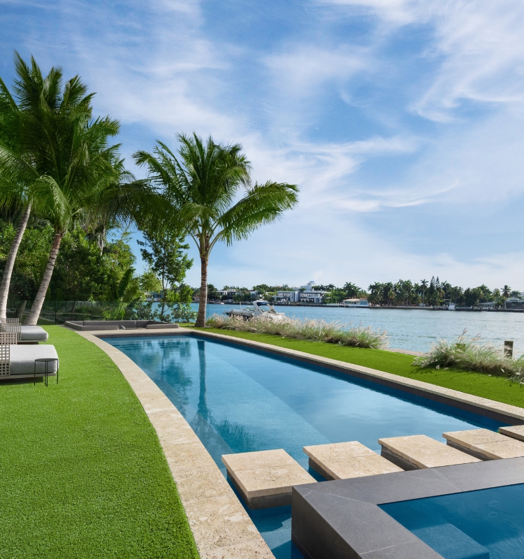 Elegant home featuring a crystal-clear pool and towering pine trees, perfect for tranquil relaxation